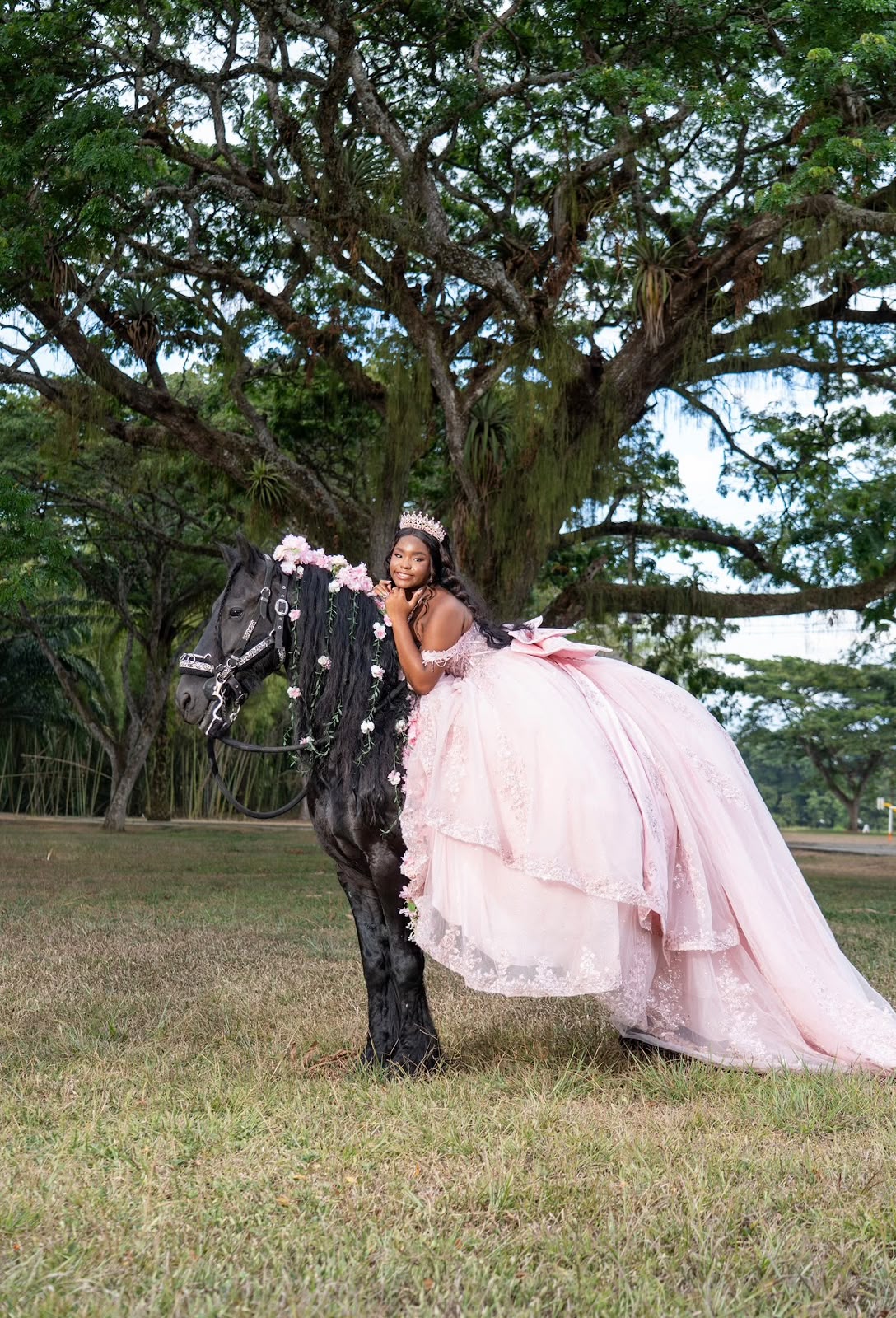 Marypaz junto a su caballo negro bajo los árboles